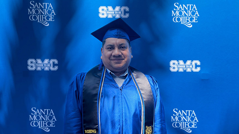 Jose Rosales in cap and gown preparing to graduate.